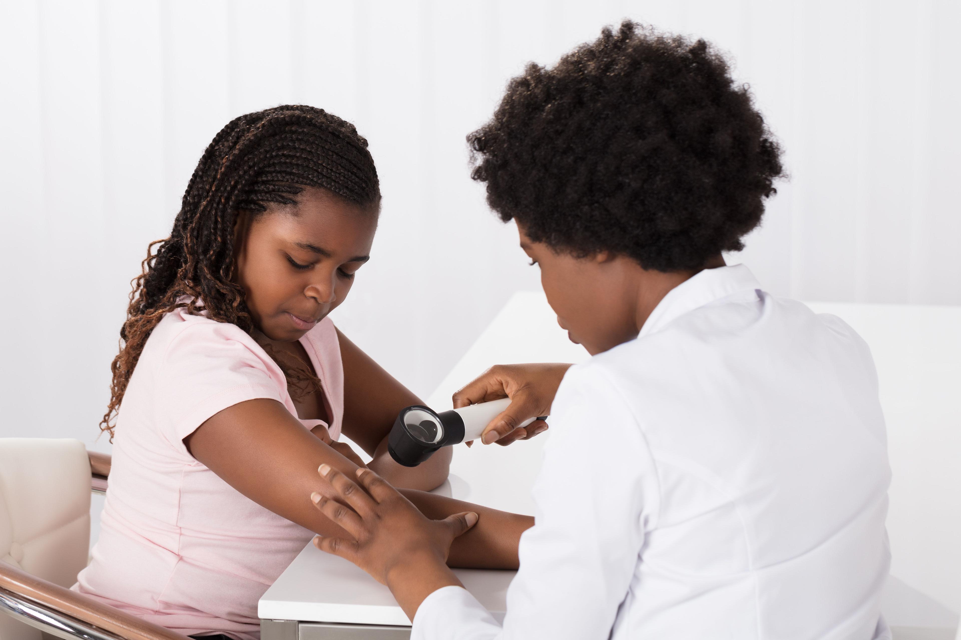 Dermatologist examines young patient's skin