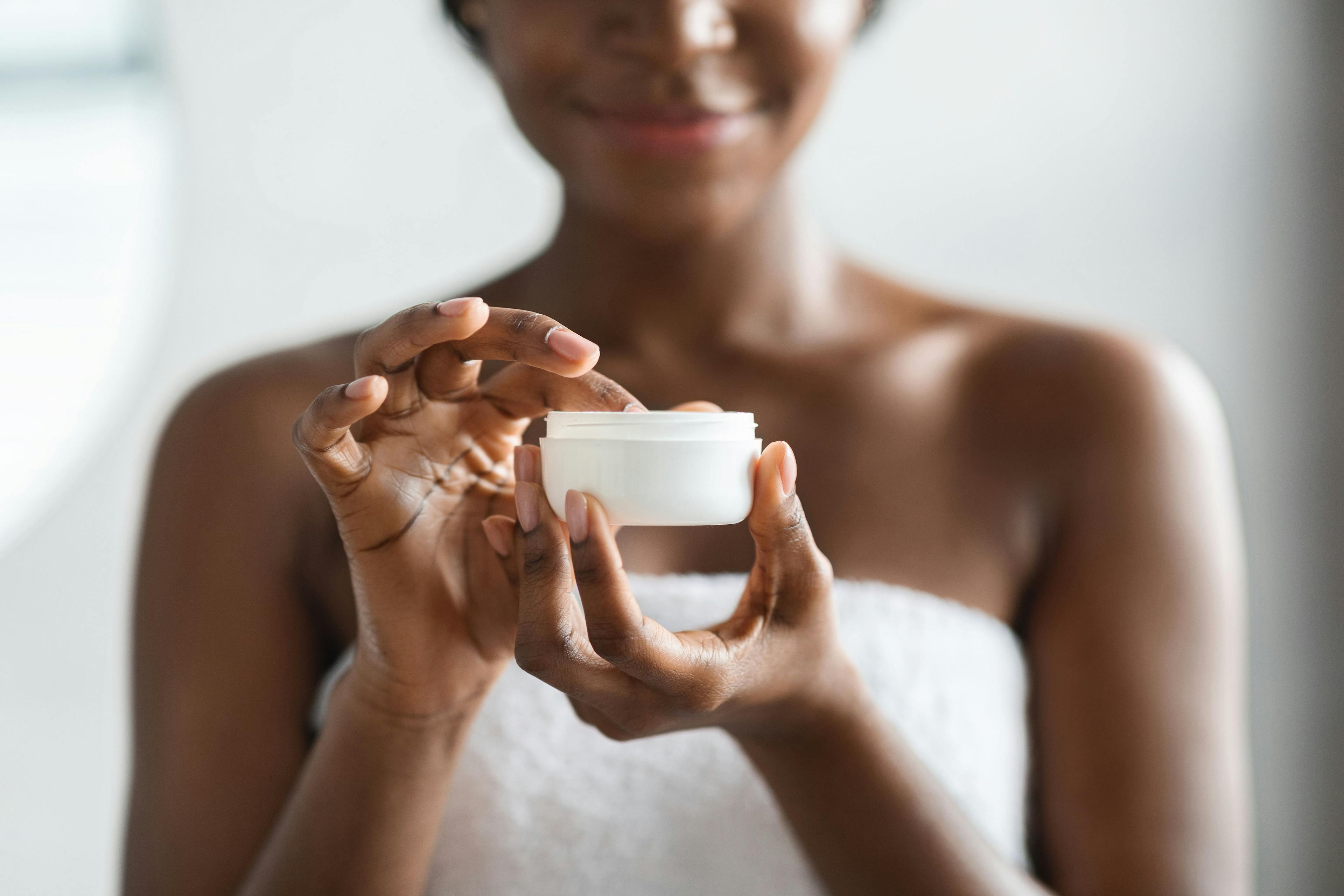 Woman with jar of skin care product